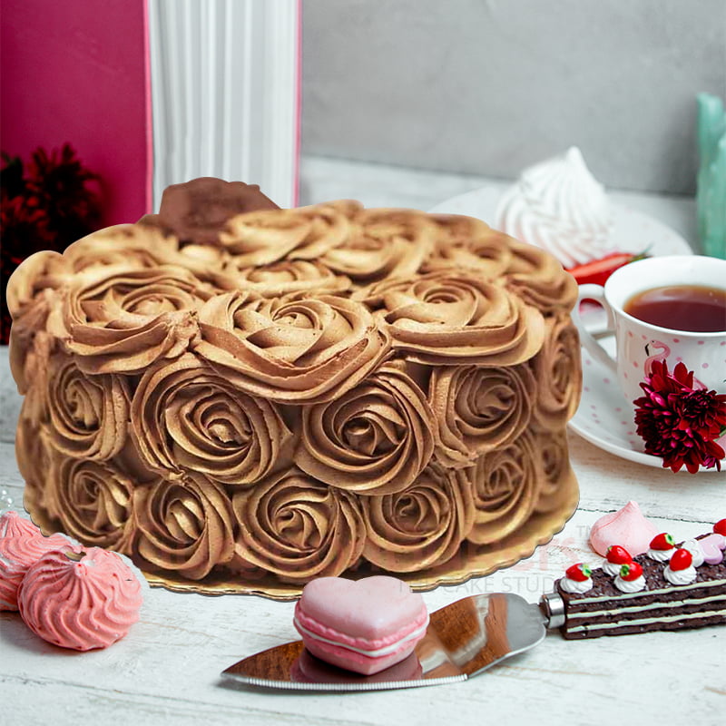 Elegant chocolate mocha cake adorned with piped mocha roses on a rustic white platter.