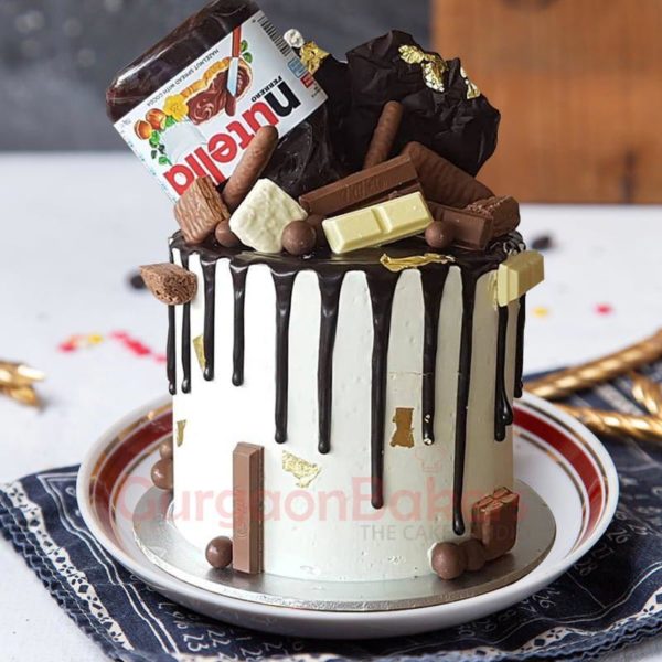 Sumptuous chocolate coffee fusion cake with chocolate sticks and assorted chocolates on top.