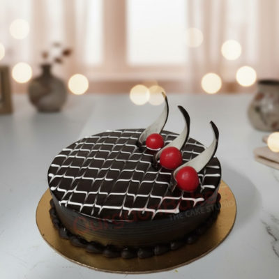 Delicious chocolate birthday cake topped with cherries and elegant chocolate decorations