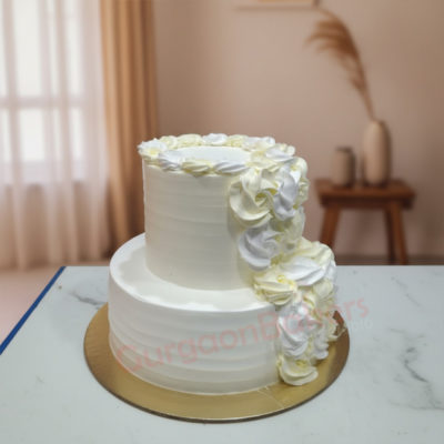 Elegant two-tier simple wedding cake with white and yellow swirl decorations