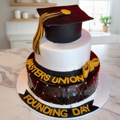 Customized graduation cake with a black cap and yellow bow for Masters Union founding day