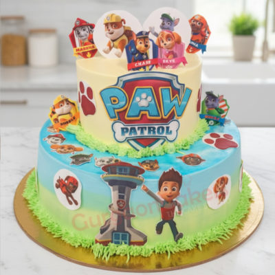Two-tiered Paw Patrol Adventure Cake decorated with character toppers and vibrant colors