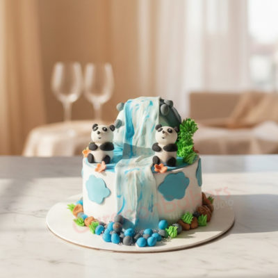 Two cute panda figurines on a cascading waterfall cake