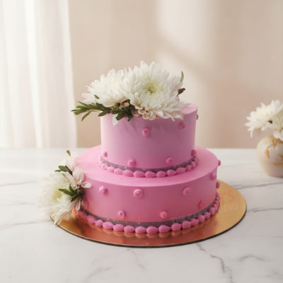 Two-tiered pink wedding cake with white flowers