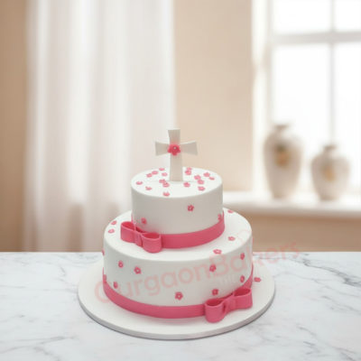 Elegant two-tiered Christian wedding cake with cross and pink bows