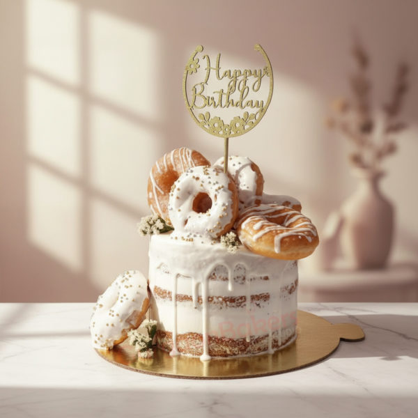 A birthday cake topped with glazed doughnuts and a golden 'Happy Birthday' topper