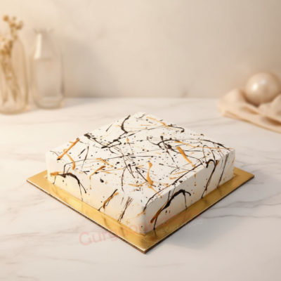 Elegant Abstract Cake decorated with black and gold splashes on a white background.