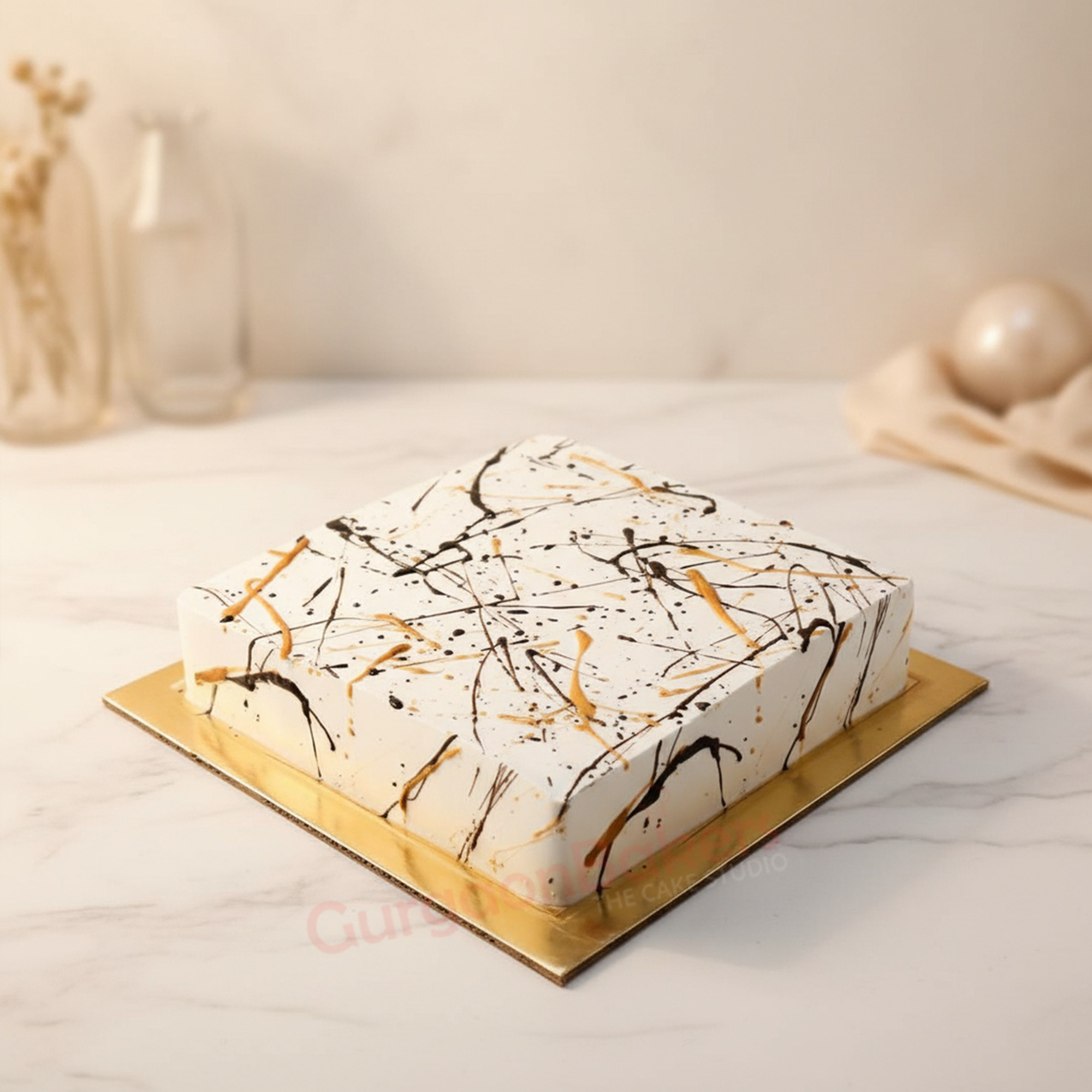 elegant-abstract-cake-gurgaon-bakers Elegant Abstract Cake decorated with black and gold splashes on a white background.