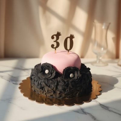 Elegant bachelorette cake with pink and black floral design and a '30' topper