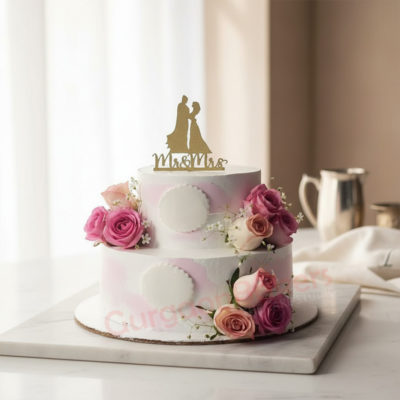 Elegant floral wedding cake with pink roses and gold topper
