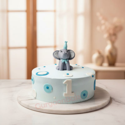 Adorable elephant birthday cake with blue polka dots and a miniature elephant figurine