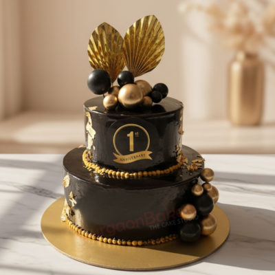Elegant black and gold first anniversary cake with decorative elements