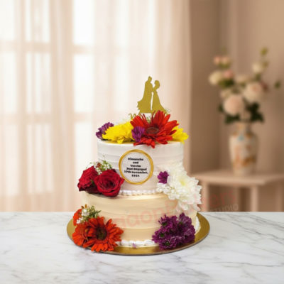 Elegant wedding cake adorned with flowers and a couple cake topper