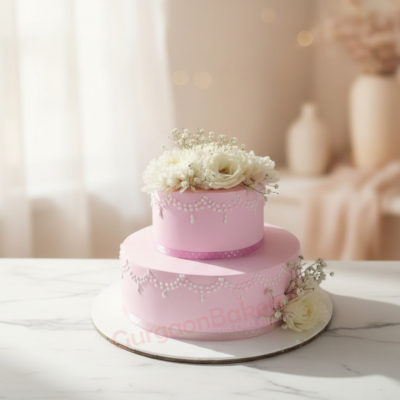 Elegant two-tiered pink engagement cake adorned with flowers