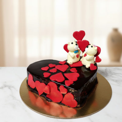 Heart-shaped chocolate cake decorated with red fondant hearts