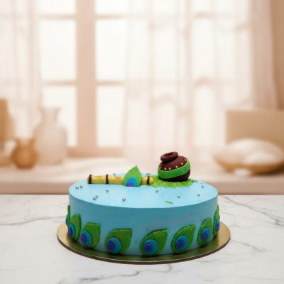 A beautifully crafted Janmashtami cake featuring a blue base, decorative peacock elements, and a clay pot.