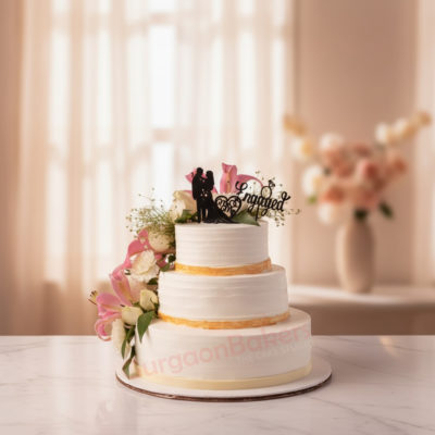 Beautiful three-tier engagement cake with floral decorations and a couple cake topper
