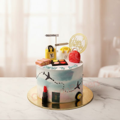 Travel-themed farewell cake featuring suitcases, makeup, and travel icons.