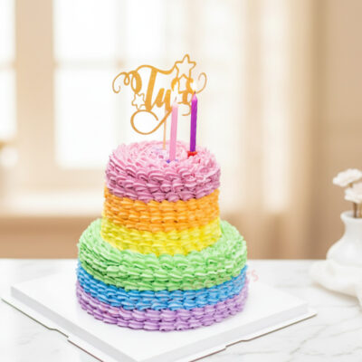 A beautiful two-tiered rainbow cake with colorful frosting and candles.