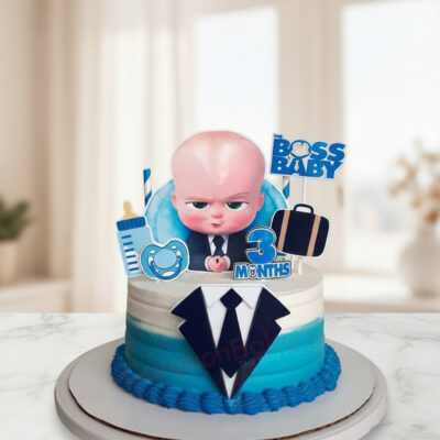 A beautifully designed Boss Baby cake featuring a character figurine, blue and white colors.