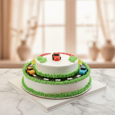 Two-tier car theme cake with vibrant car toppers and green grass icing, perfect for boys' birthday celebrations.