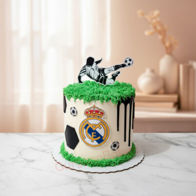 A football-themed cake with green frosting, a soccer player, and a team logo