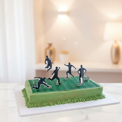 A vibrant green football themed cake with player figures