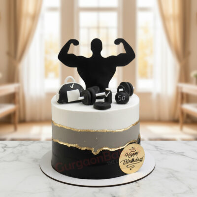 Gym Boy Cake with black and white design and fitness-themed decorations.
