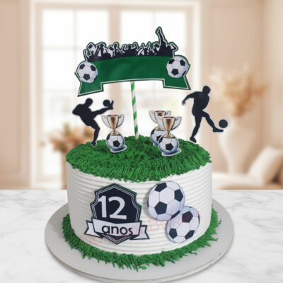 A decorated soccer-themed cake with trophies and soccer balls.