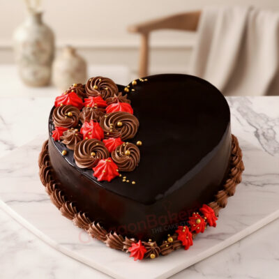 Heart-shaped chocolate cake with red and brown frosting decorations