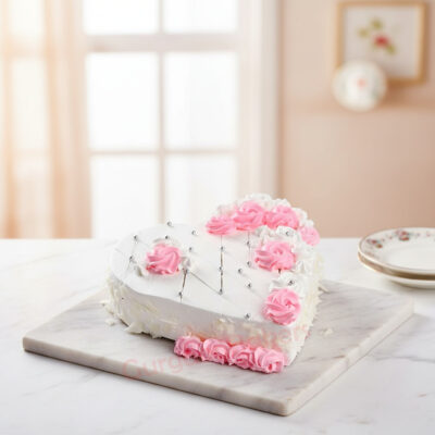 Delicious Valentine's heart-shaped cake decorated with pink roses and silver accents.