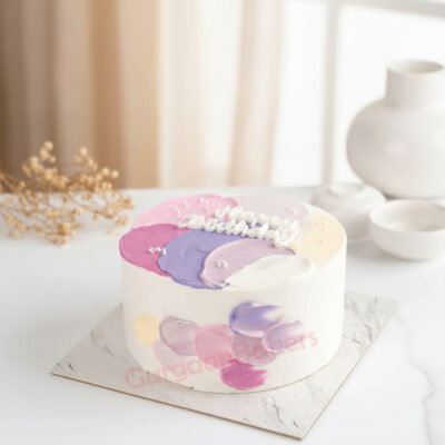 An elegantly styled birthday cake with pastel colors and floral designs
