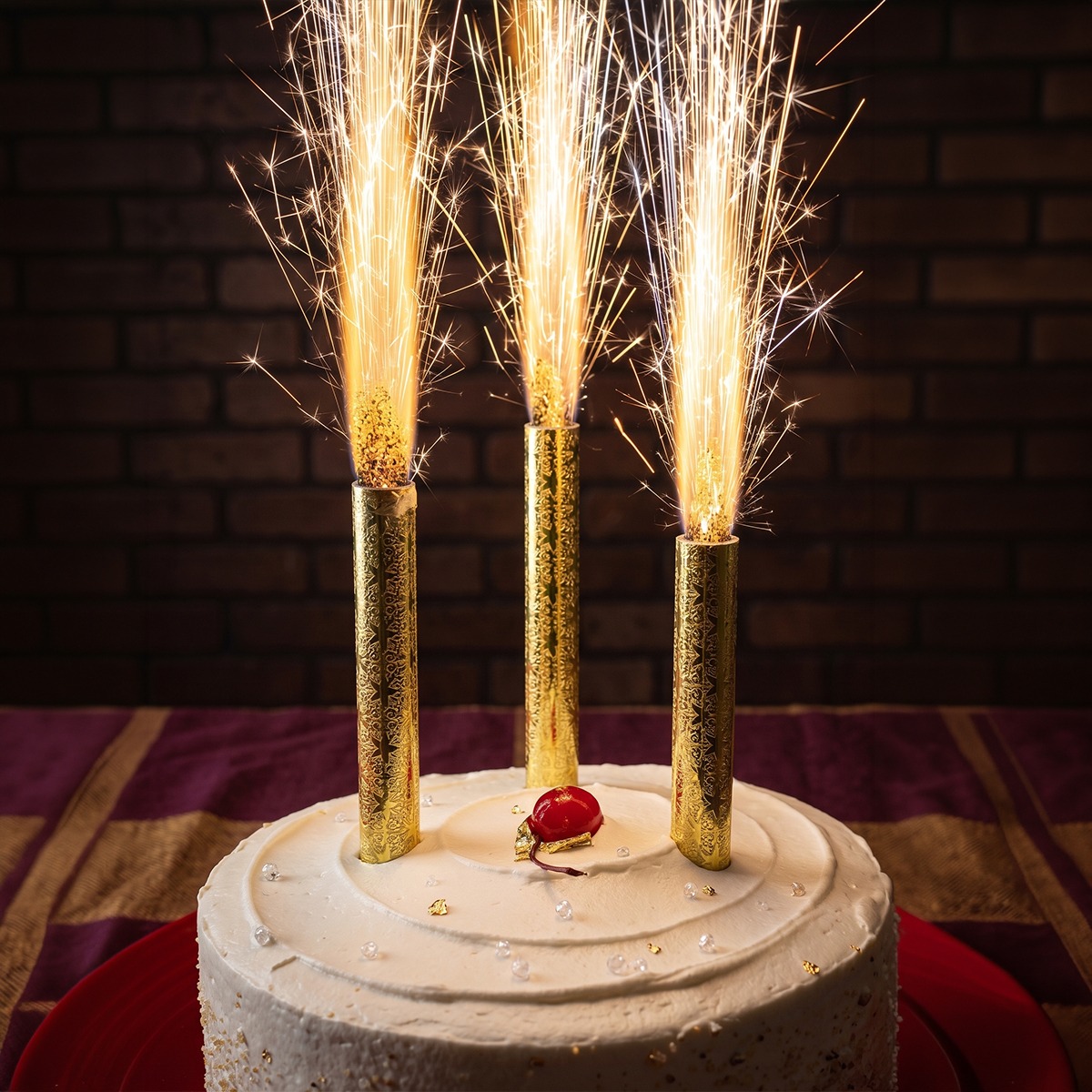 Gold Sparkler Fountain Candles Three gold sparkler fountain candles shooting sparks on top of a white frosted cake for birthday celebration in Gurgaon