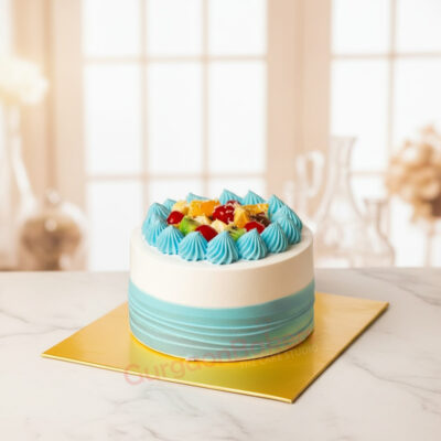 Healthy fruit cake with blue frosting and assorted fruits.