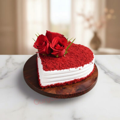 A heart-shaped romantic red velvet cake topped with fresh roses on a wooden platter.