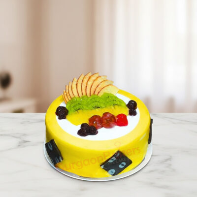 A vibrant fruit cake topped with colorful fruits including kiwi, cherries, and apples.