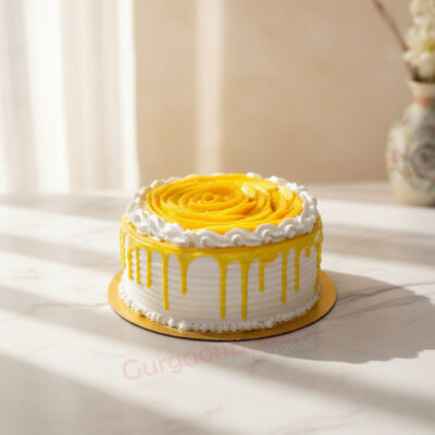 A beautifully designed mango cake with yellow frosting and white cream decoration in Gurgaon | Gurgaon Bakers