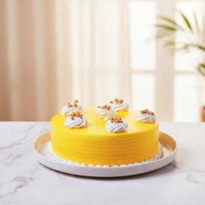 A vibrant mango delight cake topped with creamy swirls and golden spheres in Gurgaon | Gurgaon Bakers