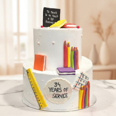 A beautifully crafted happy retirement cake with decorative elements like books and teaching tools in Gurgaon | Gurgaon