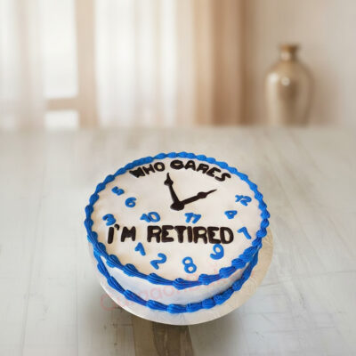 A retirement cake with a clock design and the text 'Who Cares I'm Retired' in black icing in Gurgaon | Gurgaon Bakers
