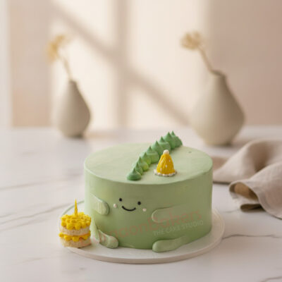 A playful T-Rex birthday cake from Gurgaon Bakers, featuring green frosting and adorable decorations.